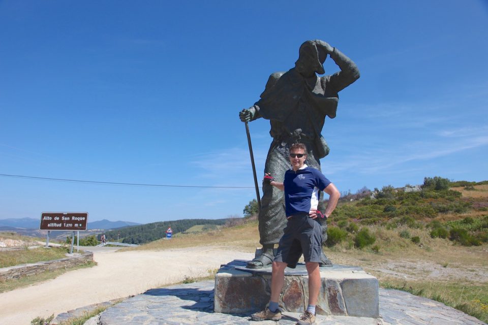 Cyclist stopped in front of statue along Camino