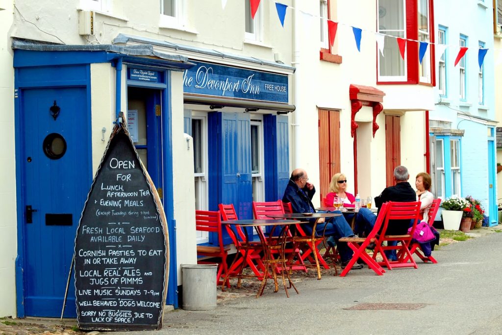 People relaxing at a table outside a Devonport Inn, UK