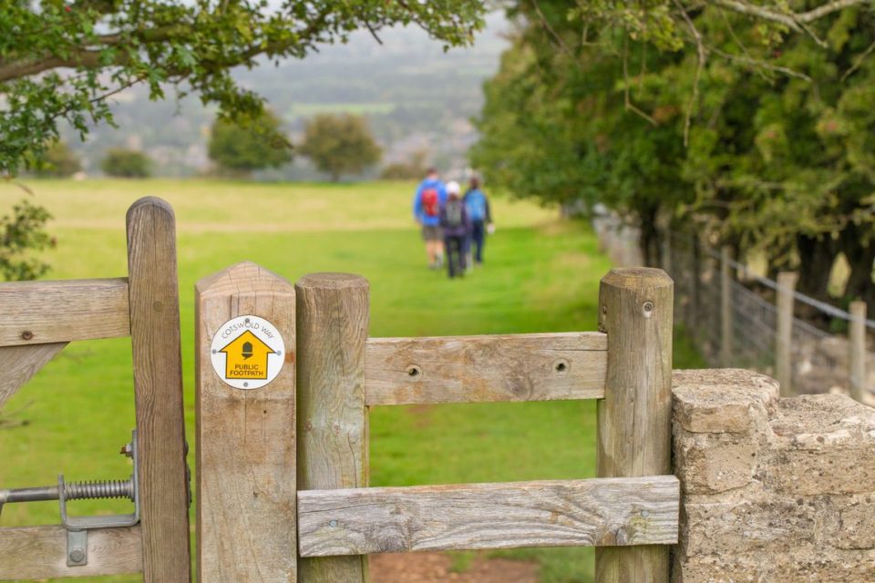 Small sign directing the way to a group of ramblers, walking the Cotswold Way. The Cotswold Way is a 102-mile (164 km) long-distance footpath, running along the Cotswold Edge escarpment of the Cotswold Hills in England. (Small sign directing the way t