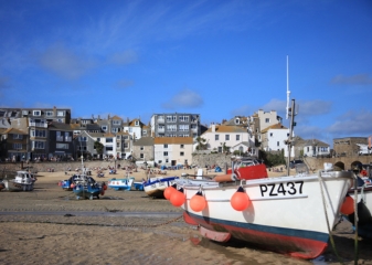 Fishing boats South West Coast Path Colorful fishing boats moored along the shore near the South West Coast Path with whitewashed houses in the background