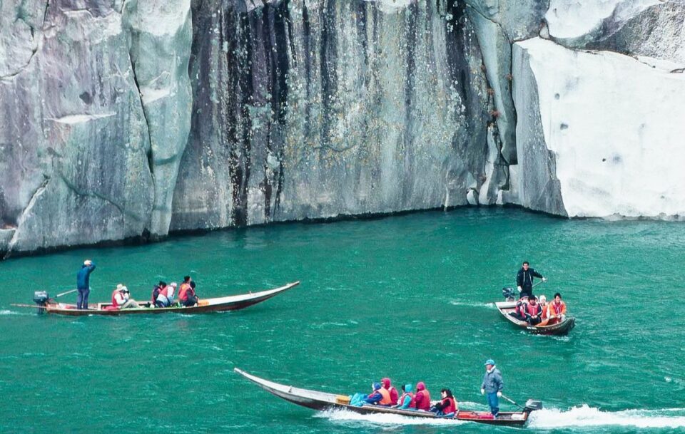 boats in turquoise water visiting the steep cliffs and caves
