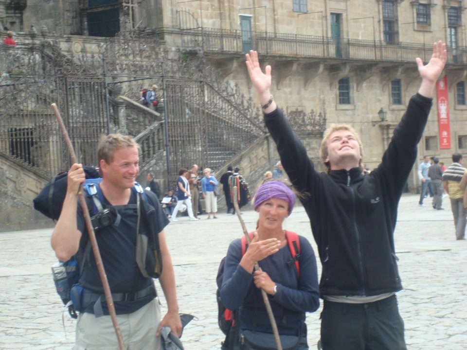 Three hikers celebrating arrival in Santiago de Compostela.