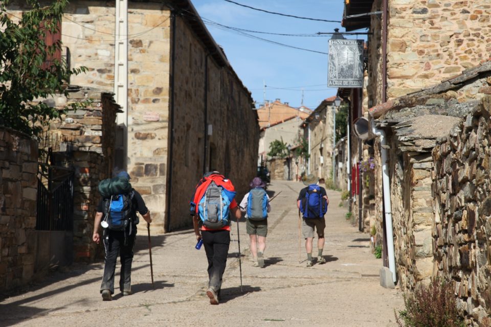 Hikers walking through an old small town along Camino