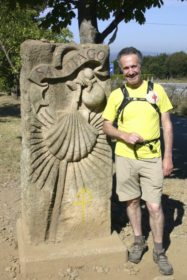 Man standing next to statue along Camino Francés.