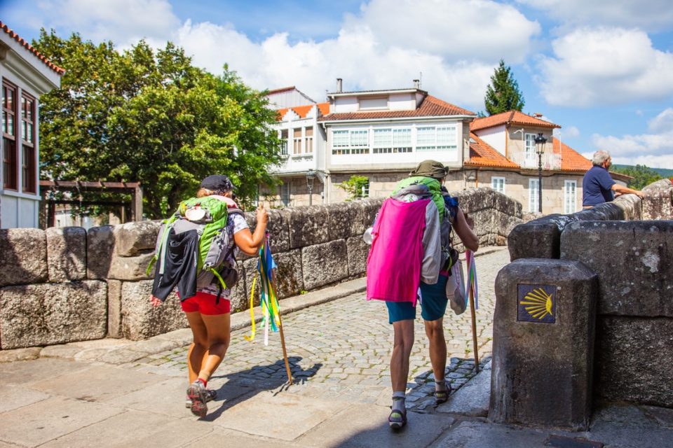 Pilgrims crossing an old bridge, Portuguese Camino