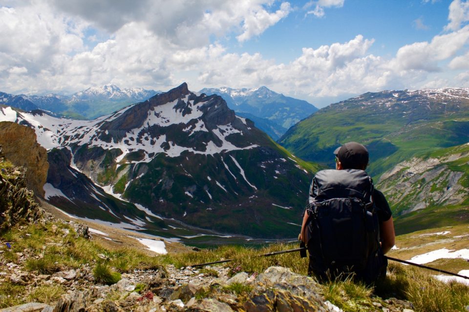 Hiker sitting looking out over the Mountains.