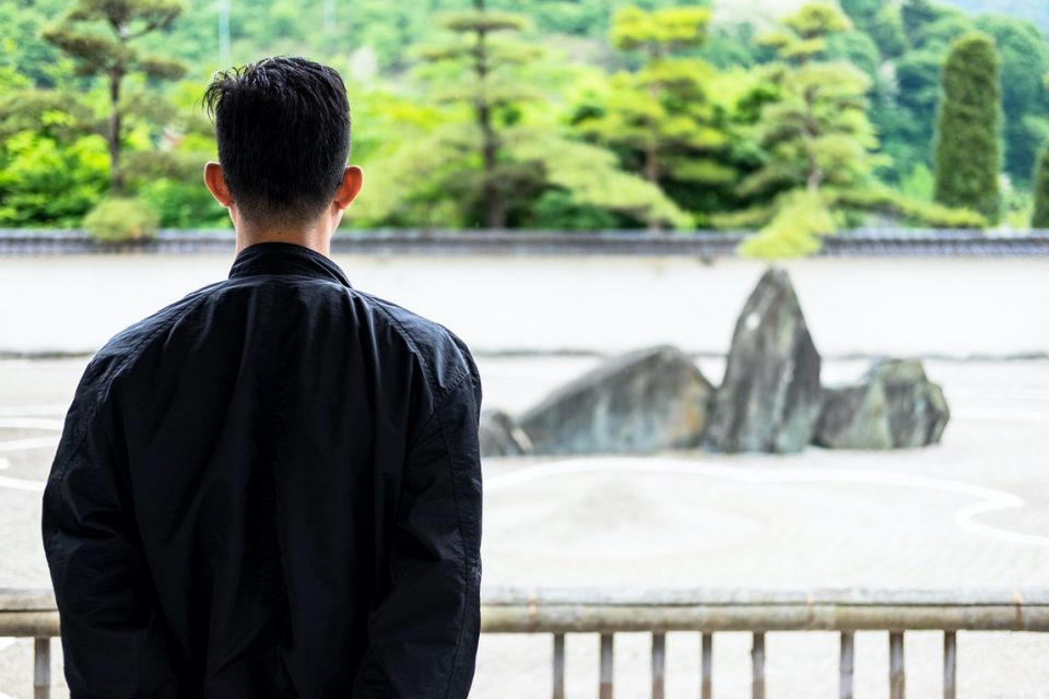 man with his back to camera looking out at view.