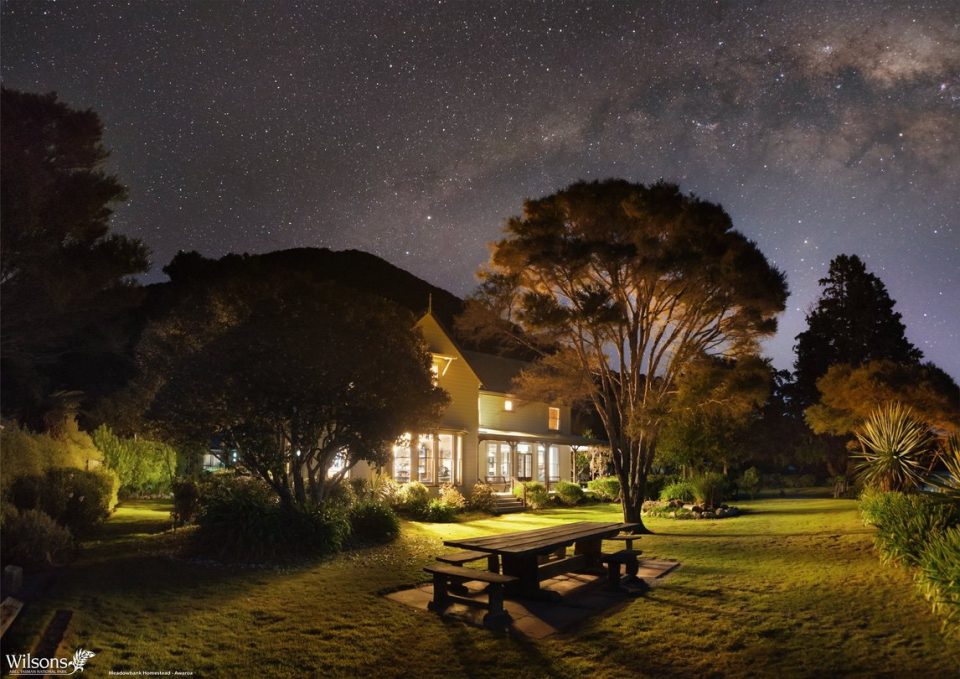 A lodge at night lit up in the bush.