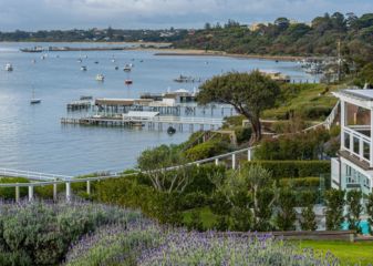 Walk Cover Image MPW (1) Beautiful homes dotted along the coast. Boats surrounding the jetties in the calm ocean.