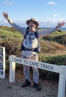Malcom, the guide, at Cape to Cape Track sign