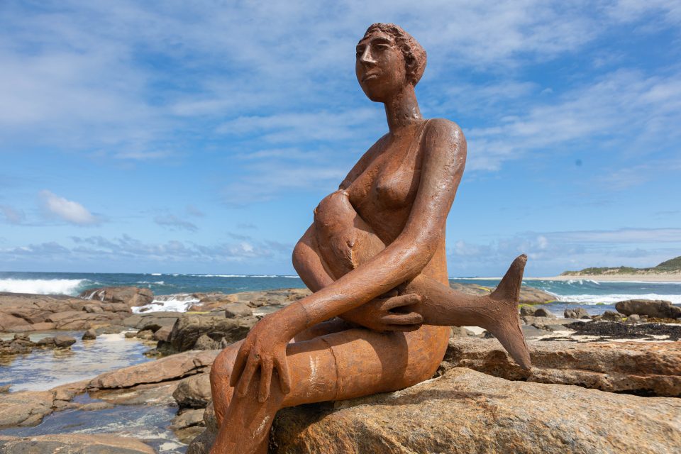 Famous stone sculpture of a woman sitting on the rocks breastfeeding her baby whale in Margaret River.