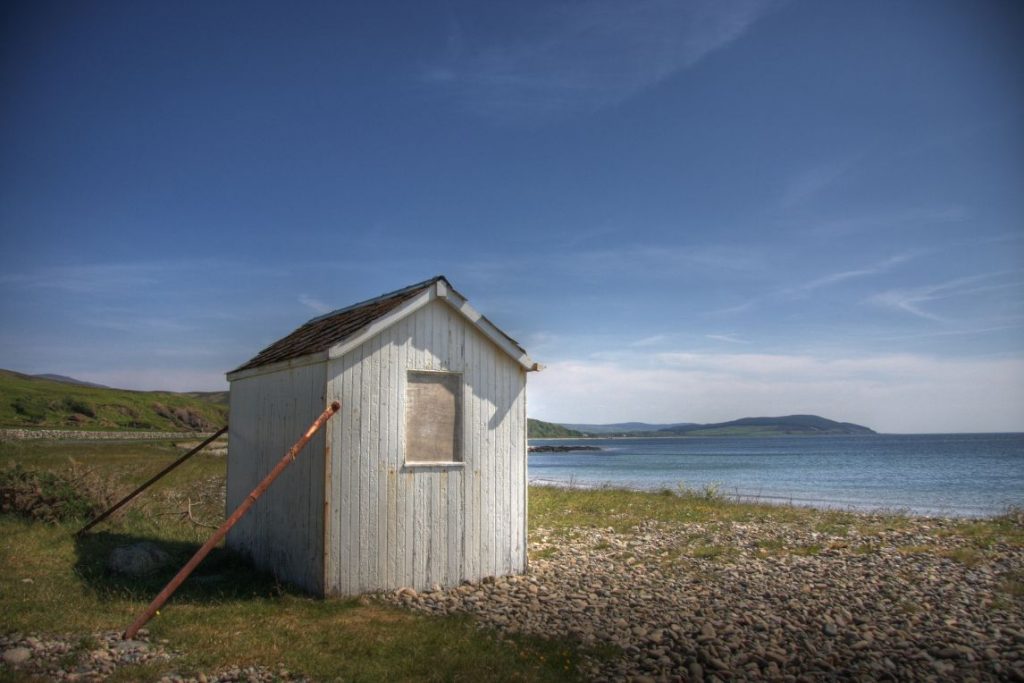Small white hut on coast.
