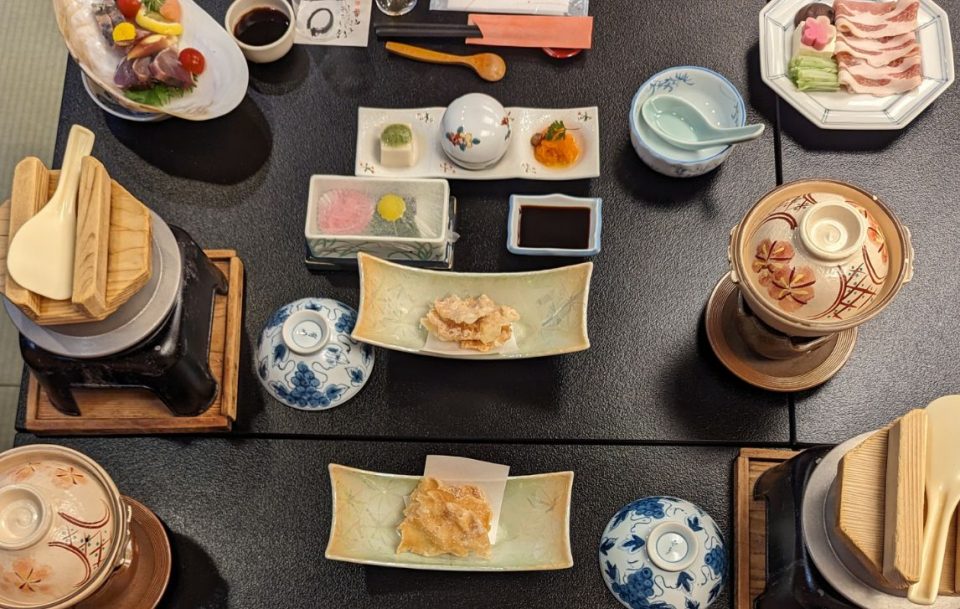An aerial view of a table filled with a variety of small plates with Japanese food