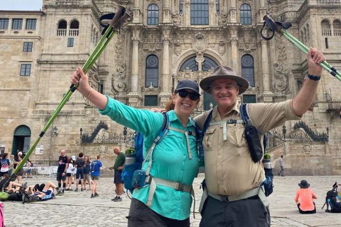 Hikers, Santiago Cathedral, Camino Frances, Spain Two hikers with their arms raised up grasping their hiking poles celebrate the end of thier Camino pilgrimage in front of the world-famous Cathedral in Santiago de Compostela, Spain.