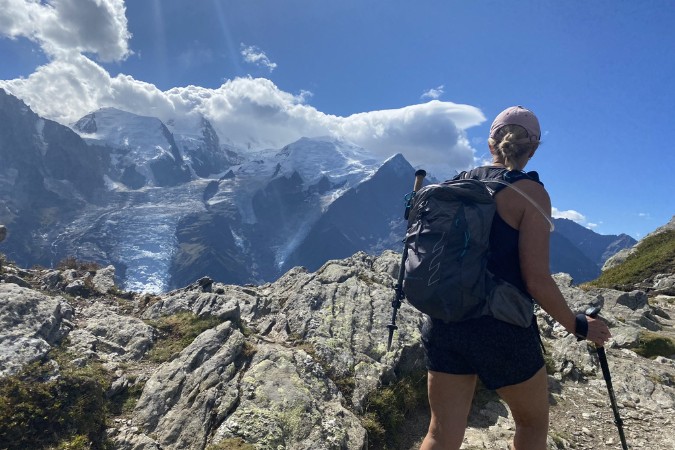Female hiker with her back to us. Looking out over Mountains.