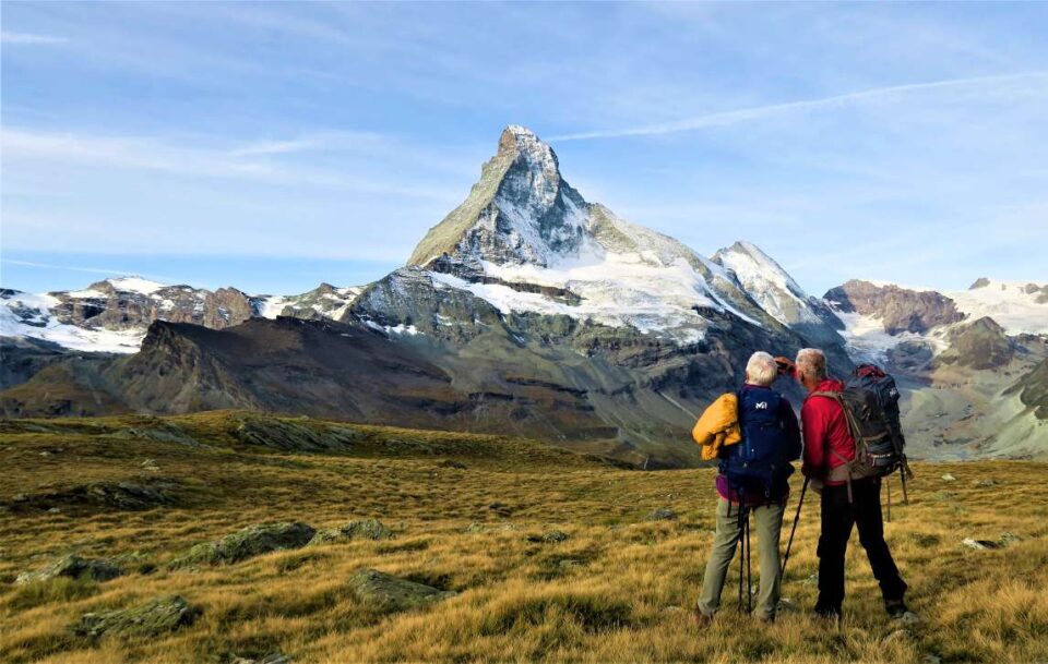 Hikers admiring the view of the Swiss Alps