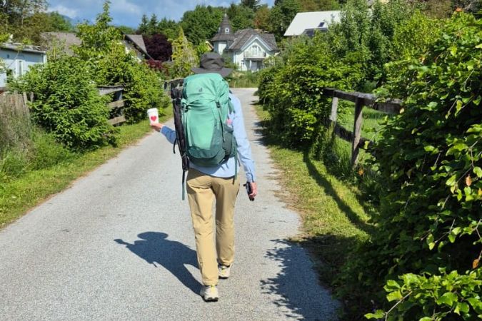 A female hiker walking along a sealed path through the picturesque Slovenian countryside