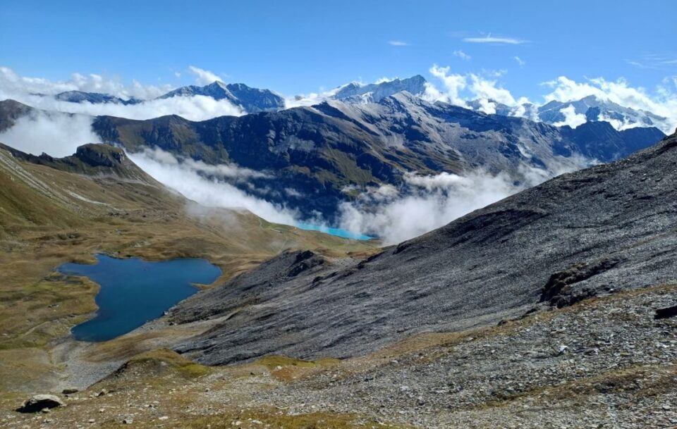 Scenic alpine panorama featuring a tranquil high-altitude lake and surrounding mountains, Walker's Haute Route, Switzerland.