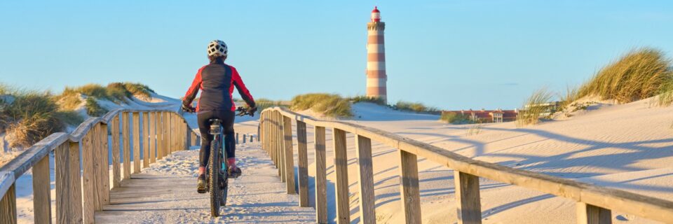 Cyclist riding a bike along the boardwalk in Portugal on the Portuguese Coastal Camino.