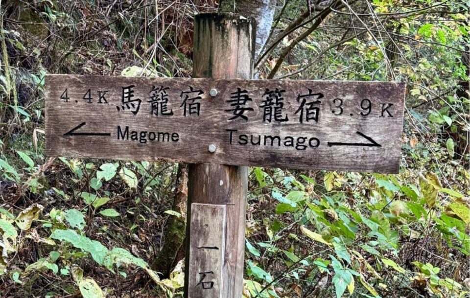Ancient wooden sign marking two directions. One Nagome, the other Tsumago, along the Nakasendo Trail.
