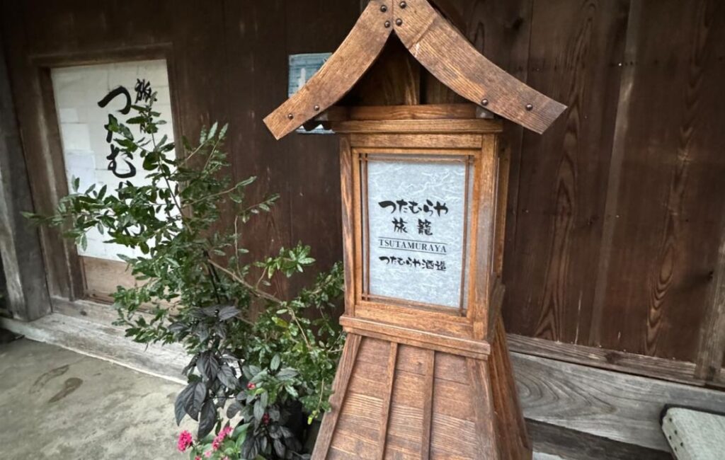 A wooden temple shaped sign showing a place to stay along the Nakasendo Way.