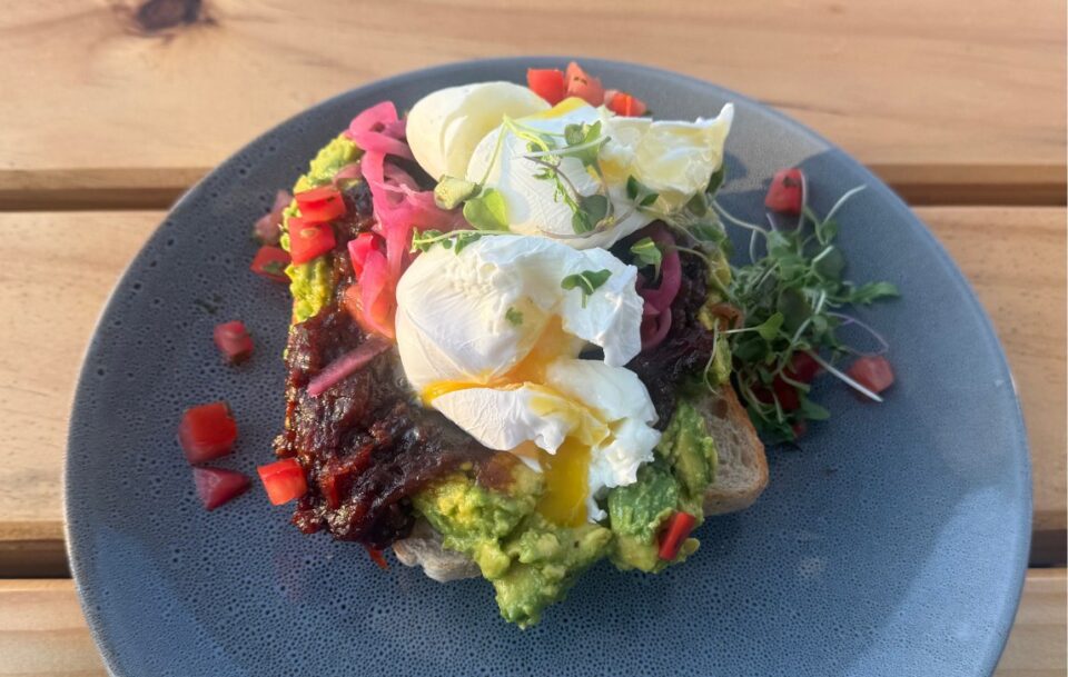 Close-up of a colourful plated breakfast featuring runny eggs on toast and artistic presentation.