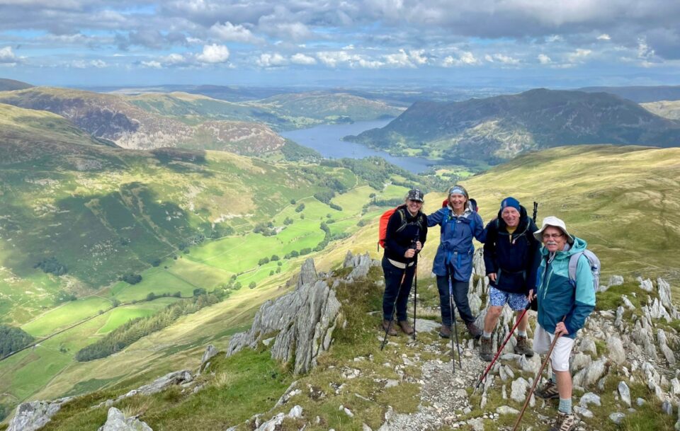 A group of hikers on top a mountain the Lake District on a sunny day
