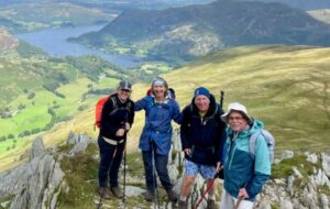 A group of hikers on top a mountain the Lake District on a sunny day