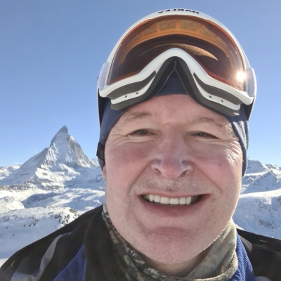 Close-up of a male mountain guide with snow-covered mountain in the background