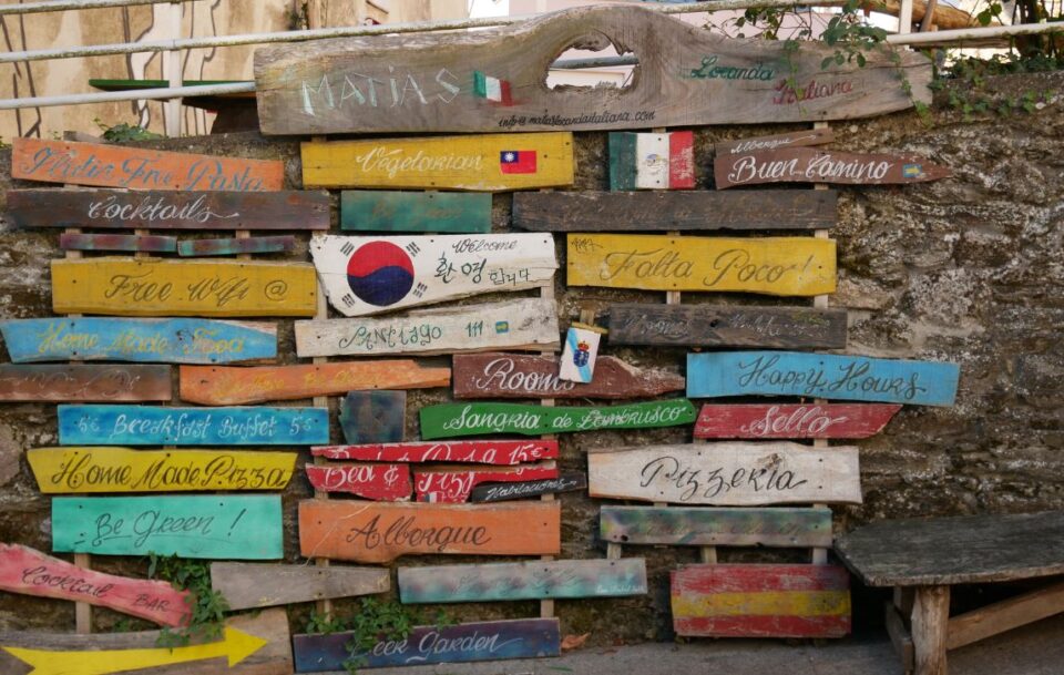 multiple signs for different things like food, wifi, accommodation all in different languages to help walkers in Santiago