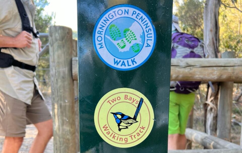 Wooden post with round signs marking the Two Bays Trail and Mornington Peninsula Walk