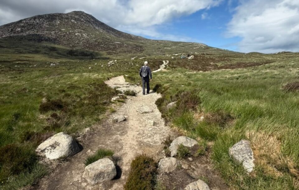 A male hiker on a narrow rocky path leading up to Goat Fell, Isle of Arran