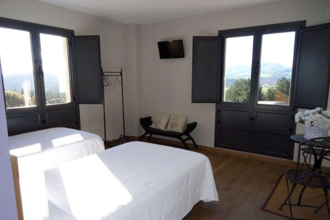 Camino Primitivo, Casa Herminia Interior of a basic hotel room on Spain's Camino Primitivo with two single beds and two windows