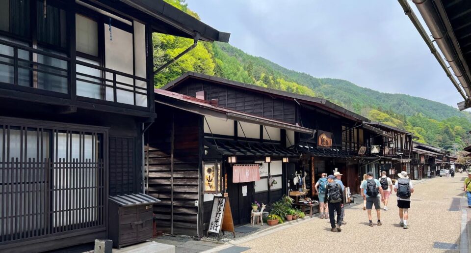 Group Hikers walking through old streets Nakasendo Japan