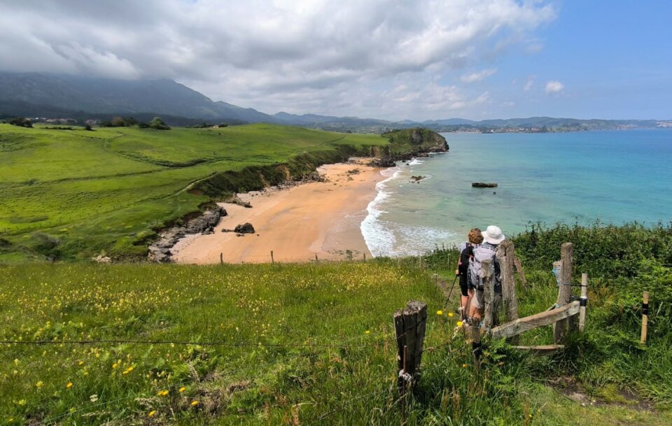 Two hikers view the spectacular coastline of northern Spain on the Camino del Norte