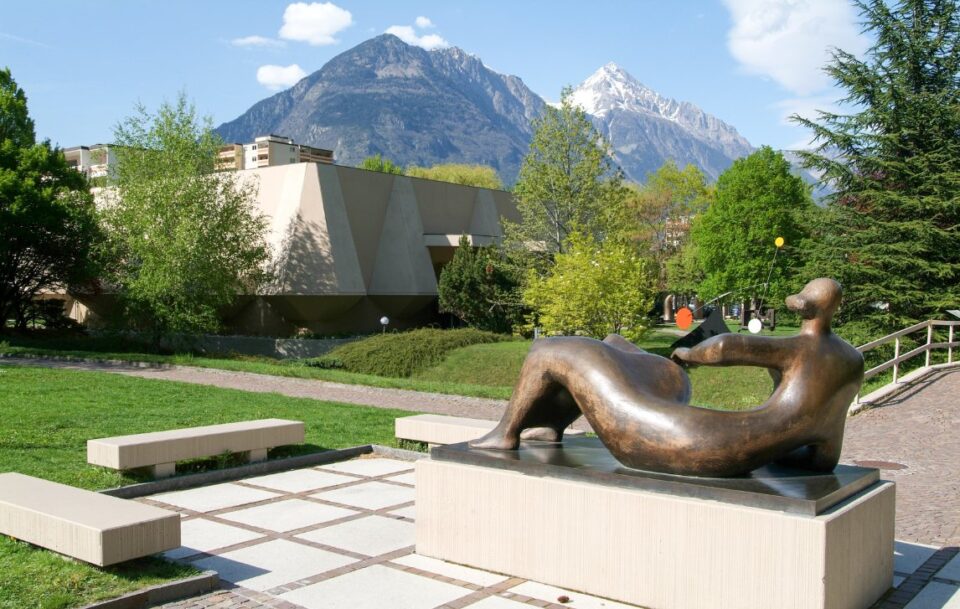 Bronze statue in the garden of the famous Museum Pierre Gianadda in Martigny, Switzerland, with snow-capped peaks in the background