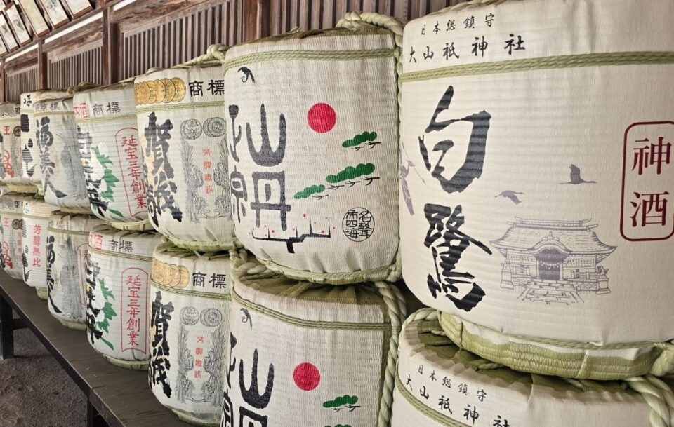 Decorative white Japanese sake barrels stacked at a temple