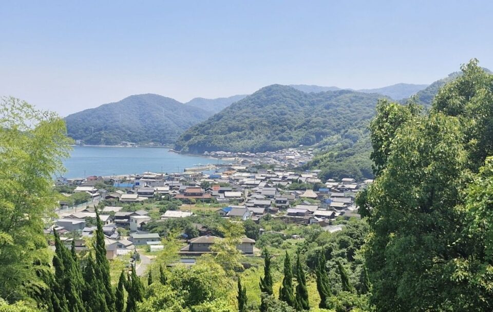 Elevated view of village roofs nestled among green mountains on an island, Shimanami Kaido