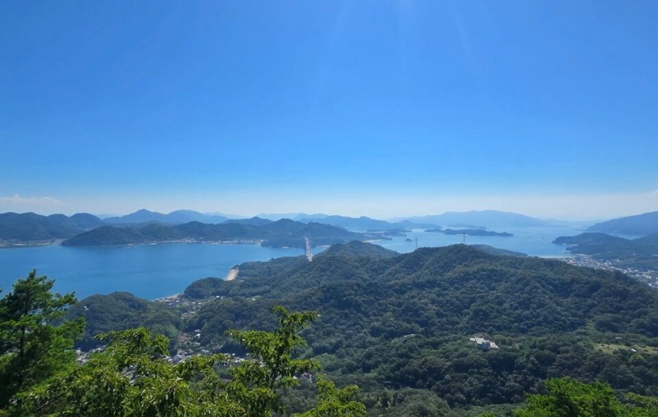 Panoramic view of Japan's Seto Inland Sea and islands covered in thick forest.