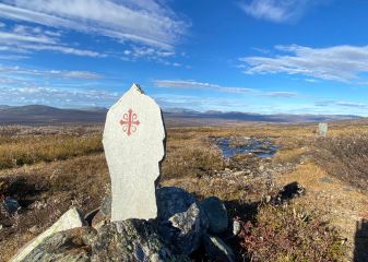 Stone waymarker with the red & white cross, symbol of St Olav's Way pilgrimage in Norway.