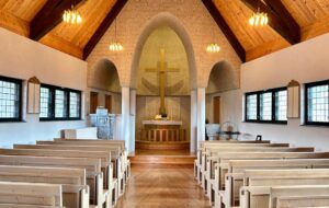 Interior of a small church on St Olav's Way with a beautiful ceiling and cross at the altar.