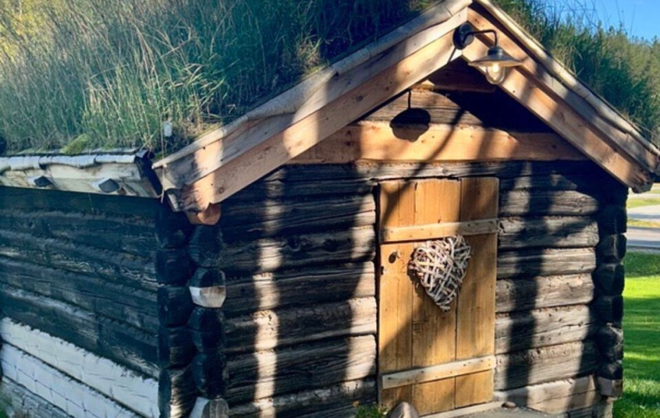Traditional Norwegian wooden turf hut with a woven heart adorning the front door, St Olav's Way, Norway.