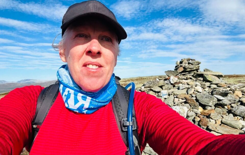 Closeup of a hiker in a vivid red top facing the camera on St Olav's Way