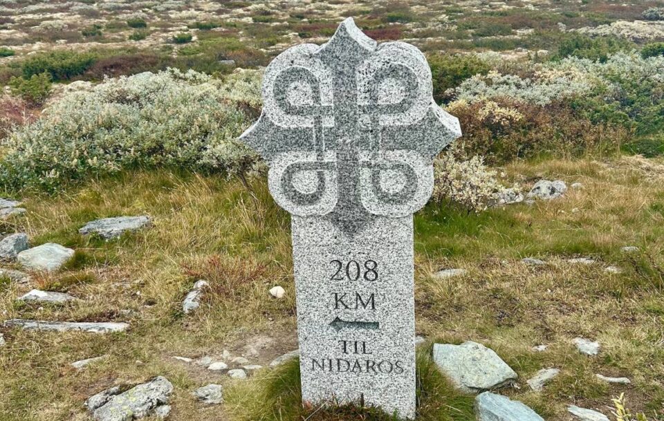 Stone St Olav’s Way trail marker on the Dovre Plateau showing 209 km to Nidaros.