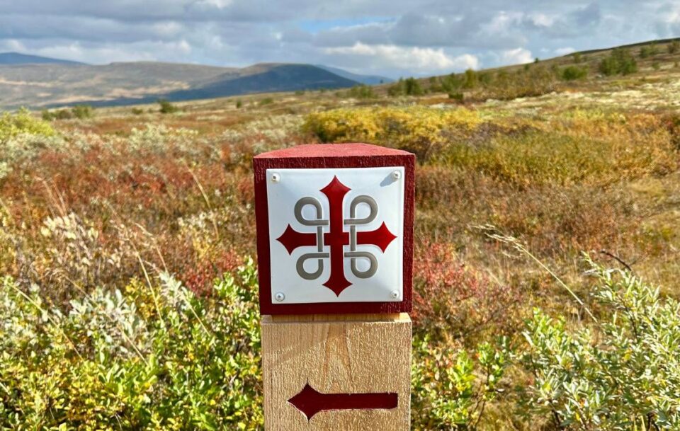 St Olav’s Way trail marker on the Dovre Plateau. The the red & white Celtic-like design is clearly displayed.