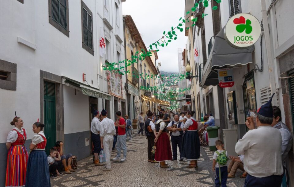 Vibrant street of Funchal, Madeira, with locals dressed in colourful traditional attire.