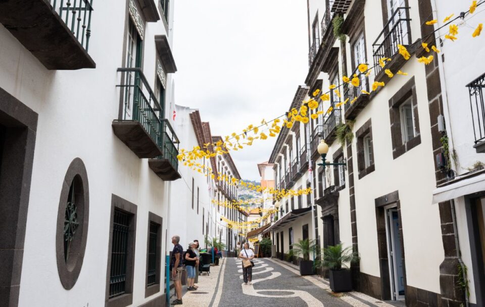 Charming narrow street in Funchal, Madeira, featuring traditional black and white façades.