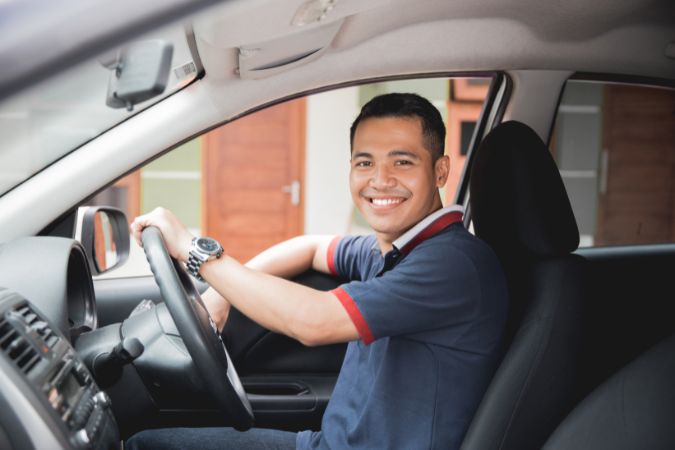 Smiling driver inside a black sport utility vehicle for private transport on Madeira Island.