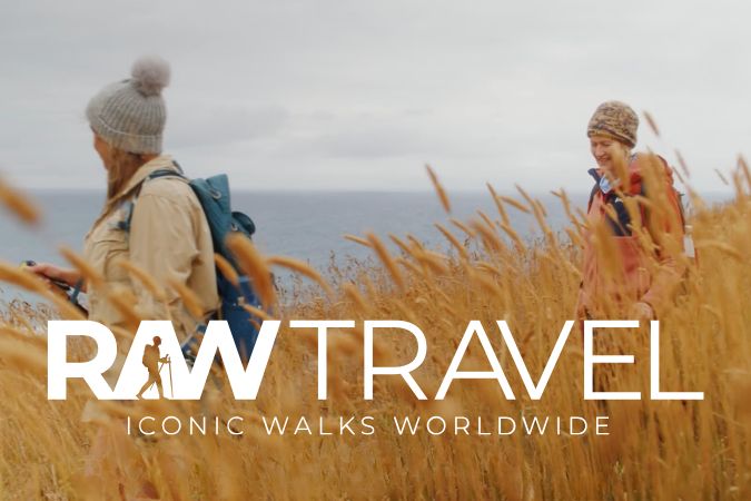 Walkers in a field along coast from brand video